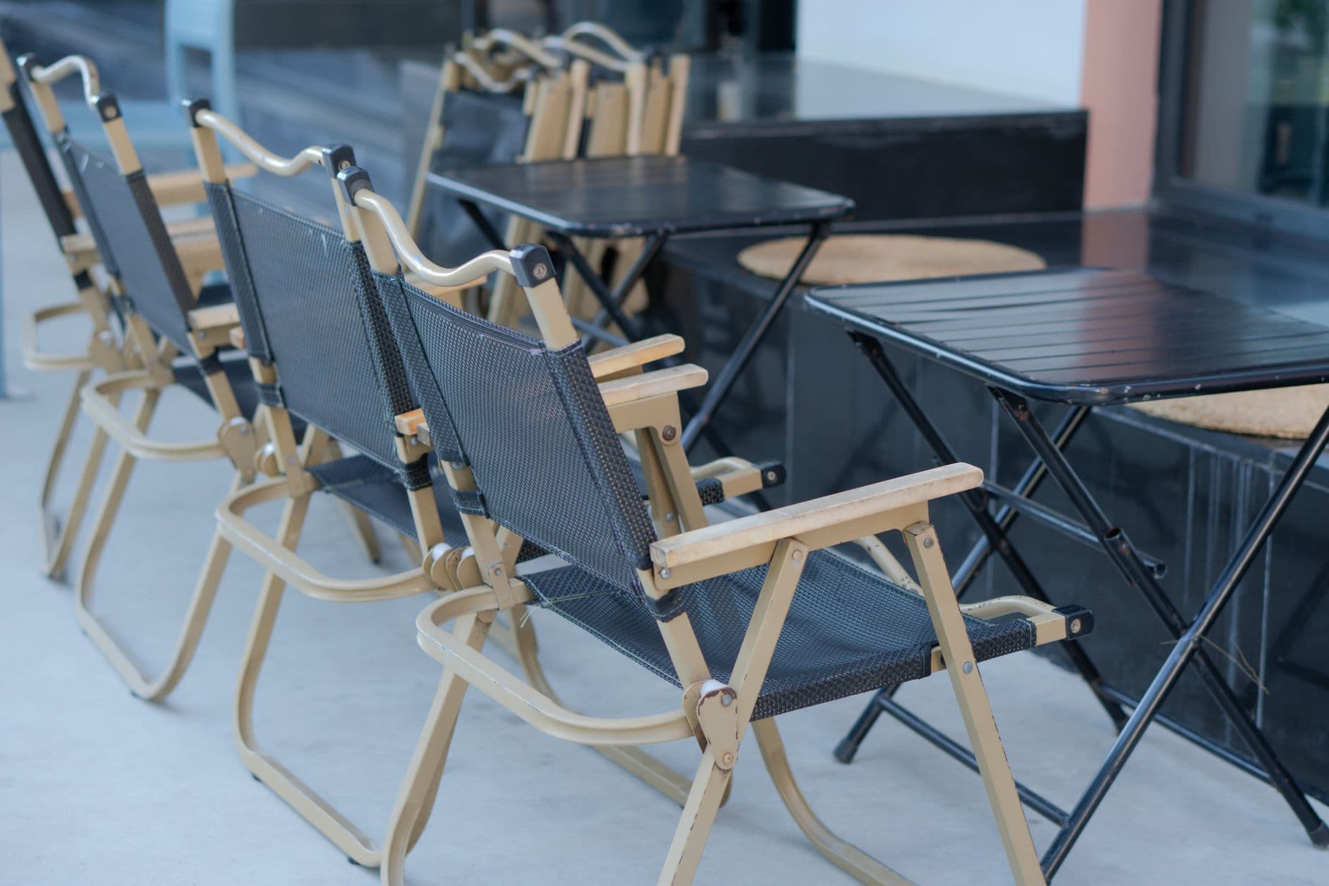 A neat arrangement of foldable chairs and tables outside, perfect for outdoor gatherings.